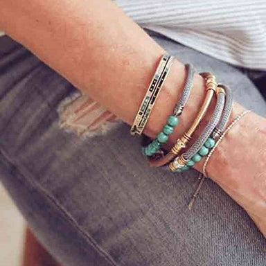 Woman wearing various ALEX AND ANI cuffs and wraps
