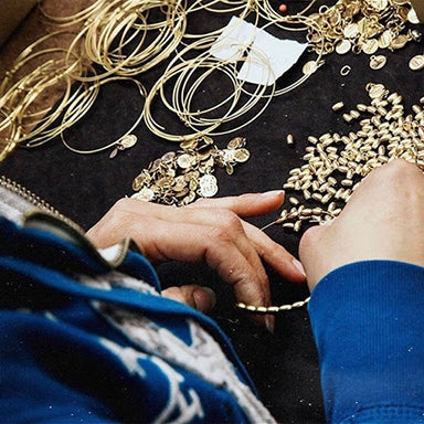 Woman constructing ALEX AND ANI bracelets