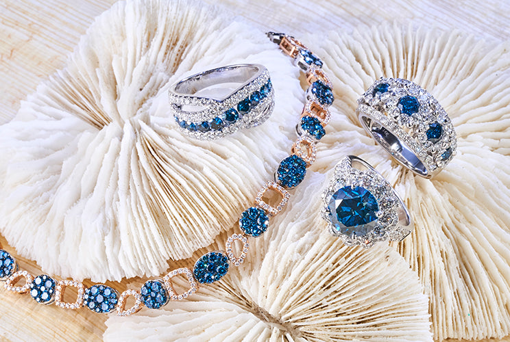 Blue diamond rings and necklacees sitting on coral