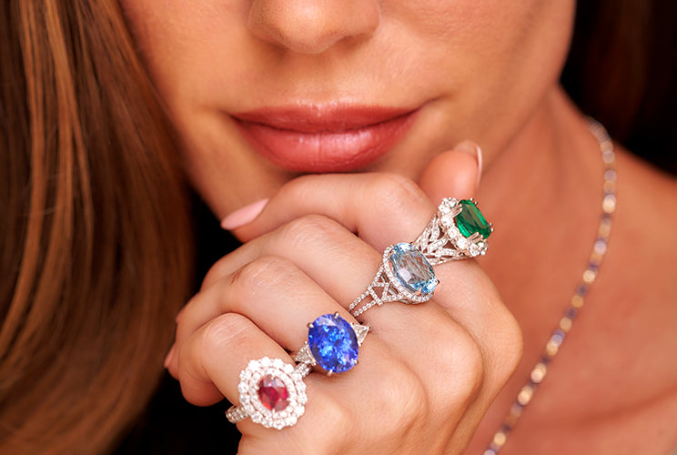 Woman wearring various gemstone rings and necklaces