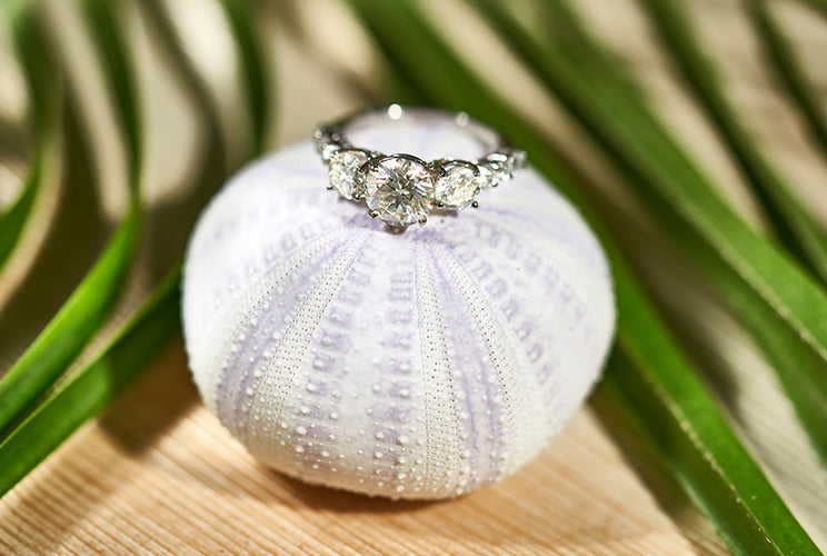 Engagement ring sitting on a pincushion